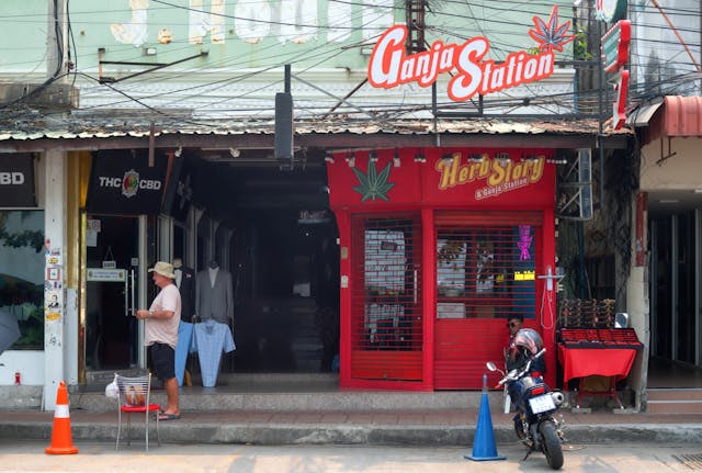 Devanture d'un dispensaire de cannabis nommé "Ganja Station" dans une rue en Thaïlande, illustrant le marché avant la loi de 2025.