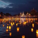 Des krathongs illuminés flottant sur un lac au crépuscule pendant la Fête des Lumières de Loi Krathong, avec des temples thaïlandais en arrière-plan.