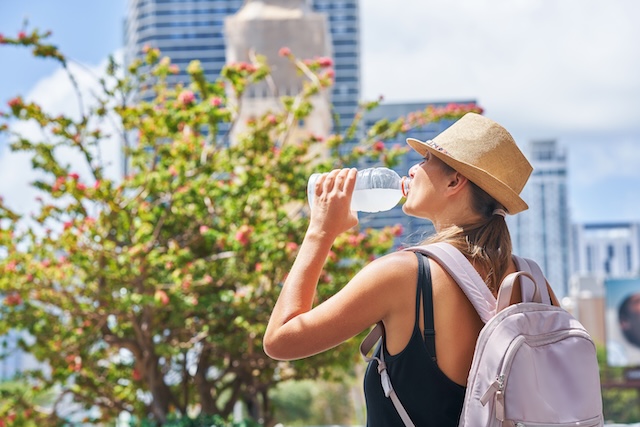 Voyageuse s'hydratant avec une bouteille d'eau dans une ville en Thaïlande.