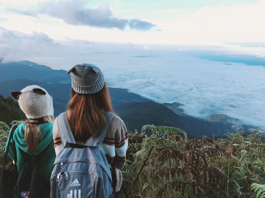 Deux voyageurs avec sacs à dos contemplant une mer de nuages en Thaïlande.
