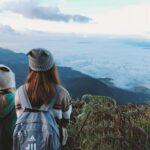 Deux voyageurs avec sacs à dos contemplant une mer de nuages en Thaïlande.