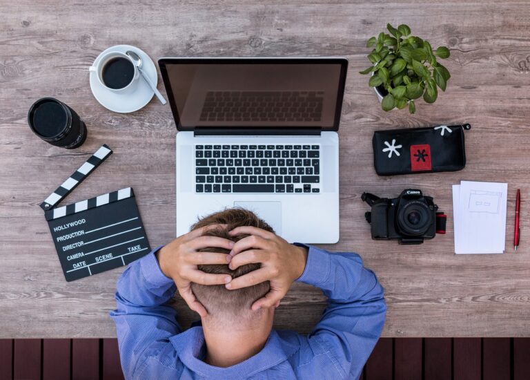 Un nomade digital se tient la tête avec frustration devant son ordinateur, illustrant les difficultés pour ouvrir un compte bancaire en Thaïlande avec un visa DTV.