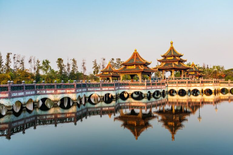 Pavillons d'un temple bouddhiste en Thaïlande se reflétant dans l'eau, illustrant les préceptes fondamentaux du bouddhisme.
