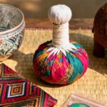 Composition de souvenirs de Thaïlande avec un éléphant en bois, une compresse de massage, un bol en céramique et des épices.