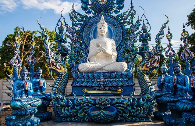 Le grand Bouddha blanc contrastant avec les sculptures et décorations d'un bleu saphir intense à l'extérieur du Temple Bleu (Wat Rong Suea Ten) à Chiang Rai.