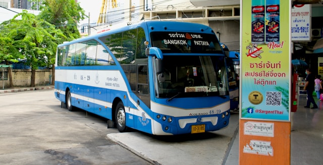 Bus bleu et blanc pour la ligne Bangkok-Pattaya stationné à quai dans une gare routière en Thaïlande.