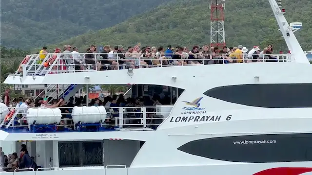 Ferry catamaran de la compagnie Lomprayah transportant des voyageurs entre Koh Samui, Koh Phangan et Koh Tao, avec des montagnes en arrière-plan.