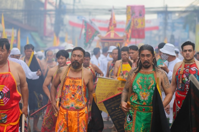 Portrait de deux médiums Ma Song en transe, portant des tabliers de cérémonie orange et vert lors du festival végétarien de Phuket.