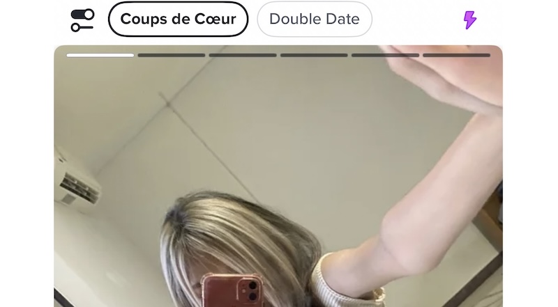 Capture d'écran de l'interface de l'application Tinder en Thaïlande, montrant un profil minimaliste typique avec une photo selfie dans un miroir.