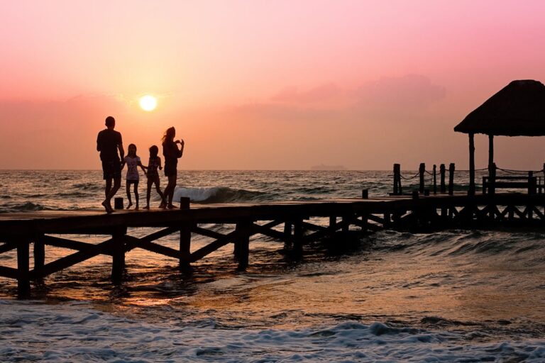 Famille avec deux enfants sur un ponton en Thaïlande au coucher de soleil, illustrant le budget d’un voyage en famille