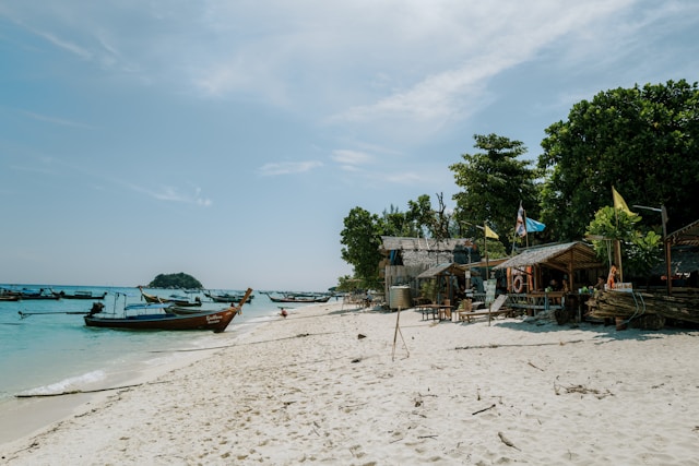 Pattaya Beach à Koh Lipe avec long-tail boats amarrés, sable blanc et petits bars en bord de plage