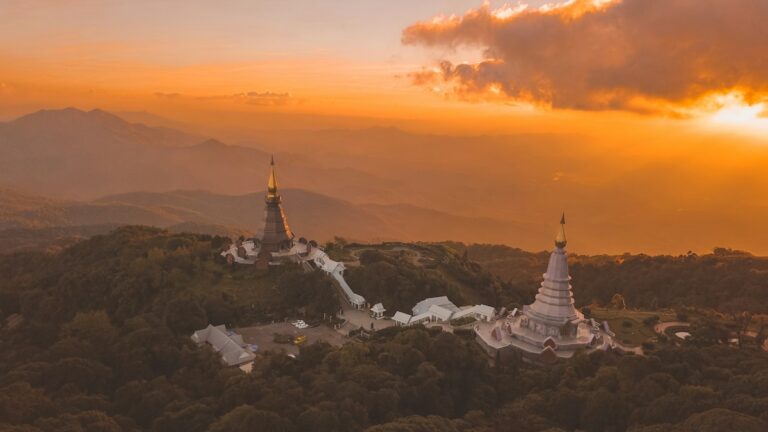 Vue aérienne des pagodes royales de Doi Inthanon au coucher du soleil, entourées de montagnes et de forêt dans le nord de la Thaïlande