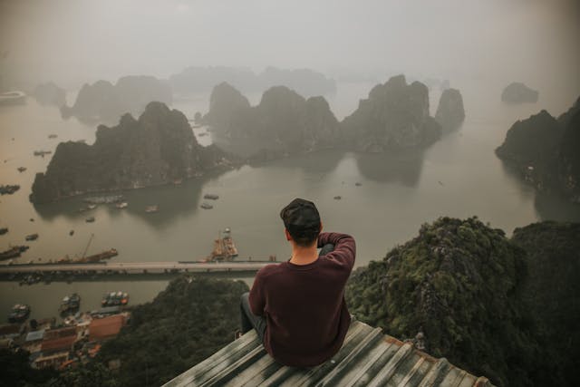 Voyageur de dos contemplant la baie d'Halong brumeuse au Vietnam