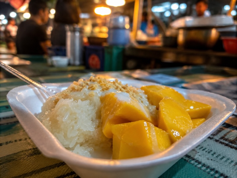 Mango sticky rice servi dans une barquette dans un marché local en Thaïlande