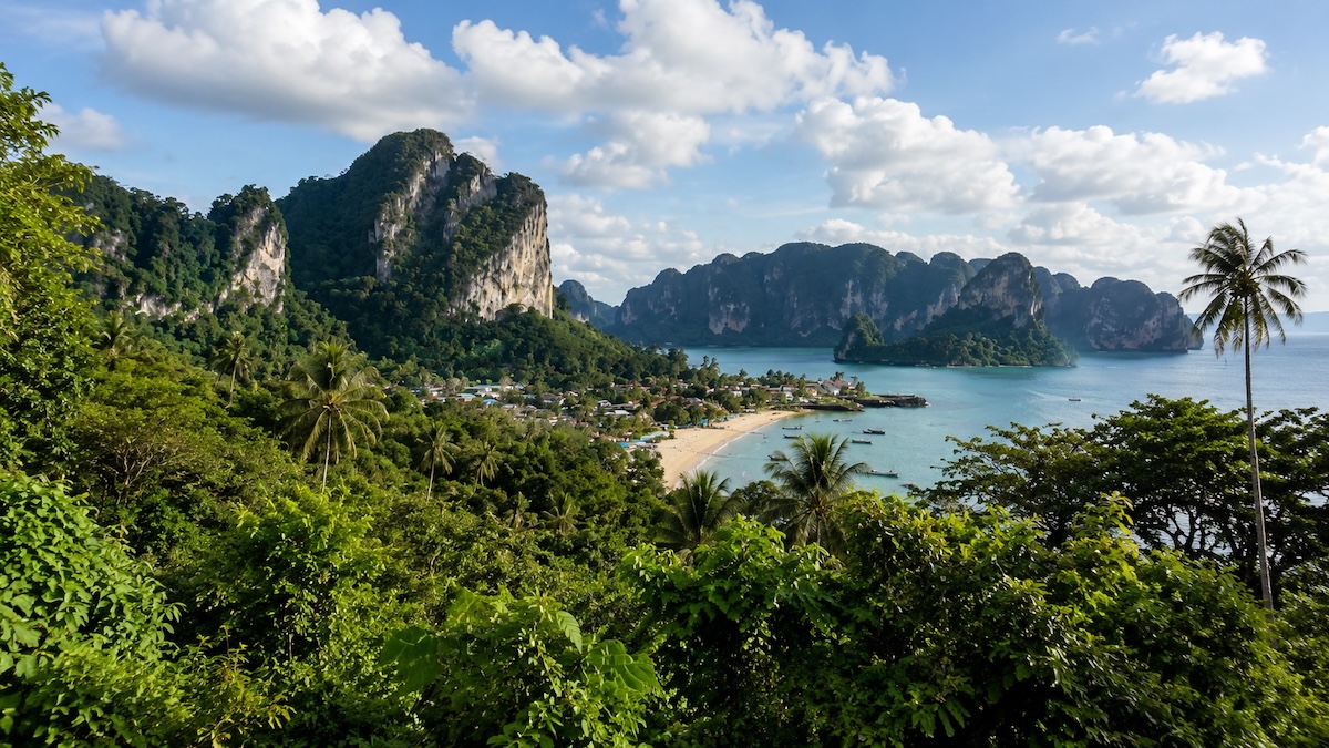 Baie tropicale entourée de falaises calcaires et de végétation en Thaïlande
