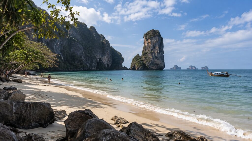 Plage de Krabi en Thaïlande avec falaises karstiques et bateau long-tail en décembre