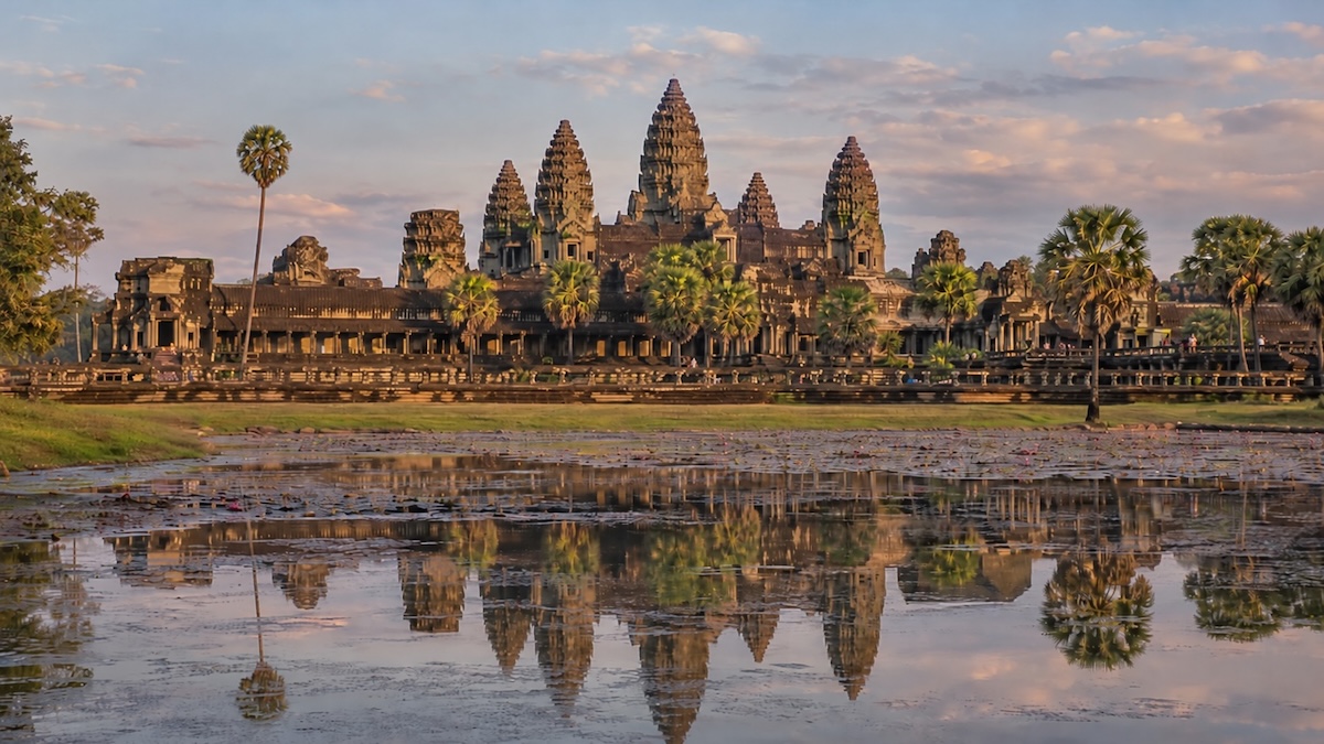 Vue du temple d'Angkor Wat au Cambodge, avec ses cinq tours et leurs reflets dans l'eau au premier plan.