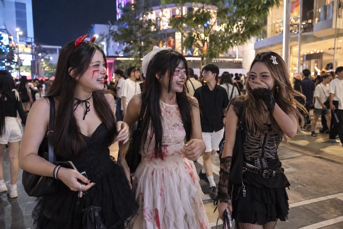 Trois jeunes femmes déguisées pour Halloween dans une rue animée de Bangkok